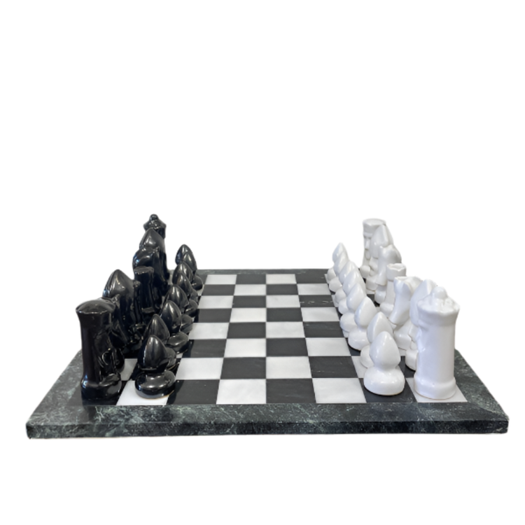 Black and white chess pieces on a checkered board with marble-like surface.