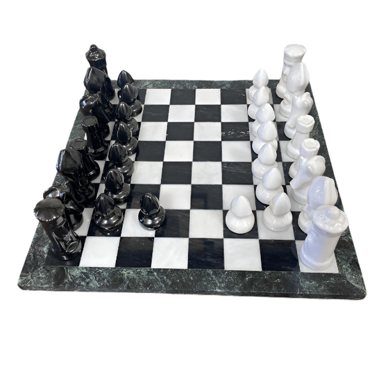 Black and white chess pieces on a checkered board with a marble-like surface.