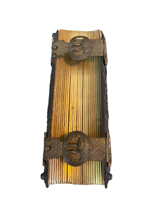 Vintage metal and wooden matchbox holder on a wooden surface