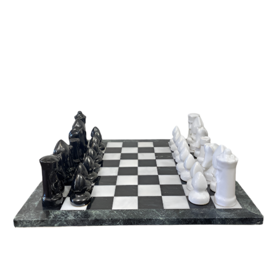 Black and white chess pieces on a checkered board with marble-like surface.