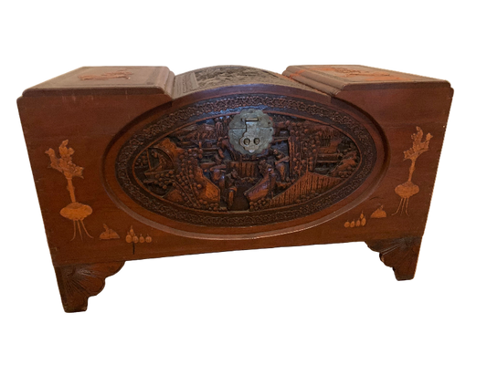 Wooden jewelry box with intricate designs on a wooden floor.