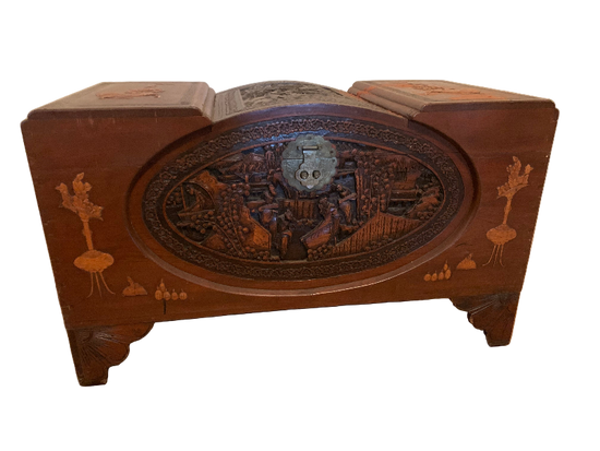 Wooden jewelry box with intricate designs on a wooden floor.