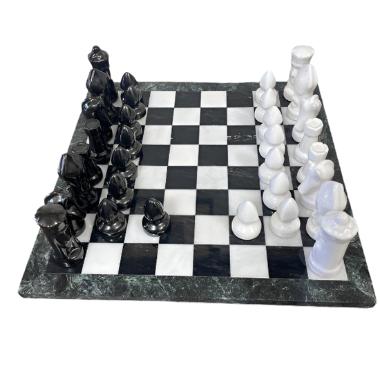 Black and white chess pieces on a checkered board with a marble-like surface.