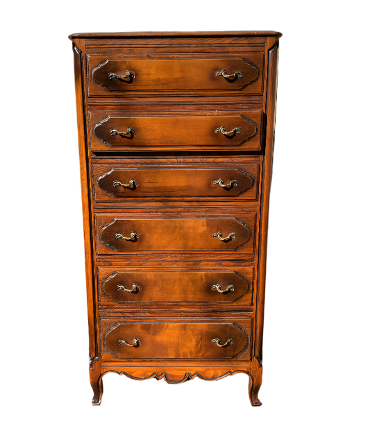 Wooden dresser with decorative carvings on a wooden deck